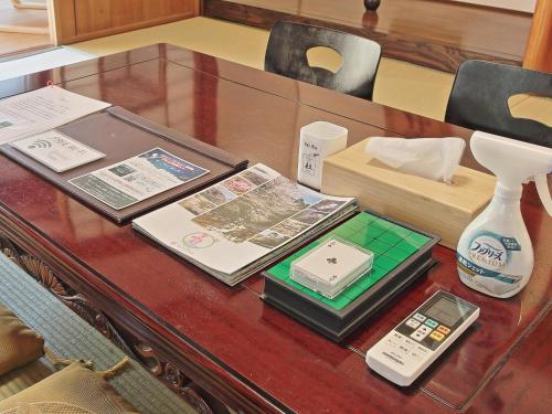 a table with a cell phone and a vase on it at GUESTHOUSE & SAUNA 杜（mori） in Kushimoto