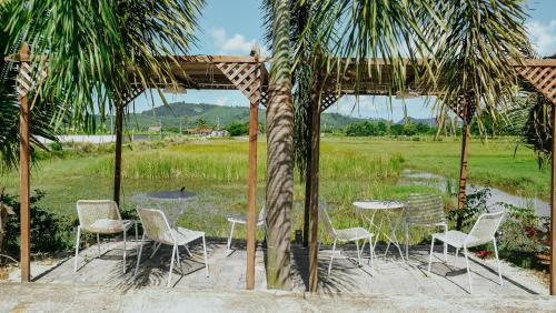 a group of chairs and tables under a gazebo at Destini Akef Villa in Pantai Cenang