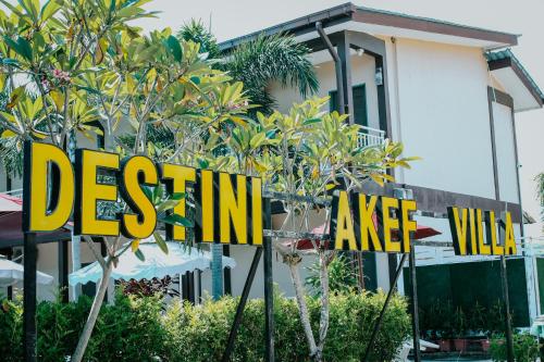 a sign in front of a house with palm trees at Destini Akef Villa in Pantai Cenang