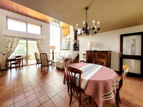 un salon avec une table et une salle à manger dans l'établissement Maison T4 climatisée, parking, véranda, jardin clos, proche plage et commerces, idéale 6 personnes - FR-1-794-137, à Canet