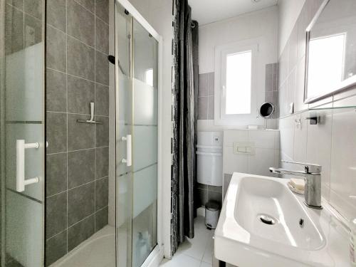 une salle de bain blanche avec un lavabo et une douche dans l'établissement Maison T3 climatisée à Canet - 6 pers, terrasse, parking, proche mer - FR-1-794-134, à Canet