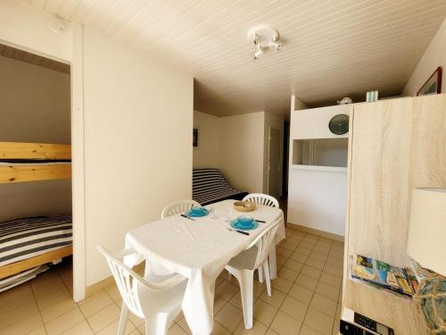 - une table et des chaises blanches dans une chambre avec un lit dans l'établissement Studio cabine avec terrasse, accès direct plage, WIFI, clim, parking privé - 4 pers. - FR-1-794-149, à Canet
