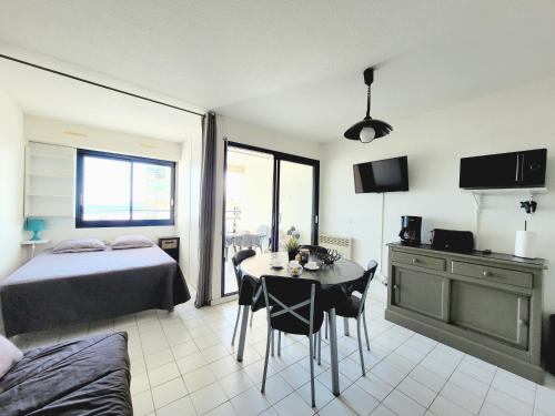 une chambre avec un lit et une table avec des chaises dans l'établissement Canet-en-Roussillon - Studio alcôve 4 pers - Terrasse - Parking privé - FR-1-794-138, à Canet