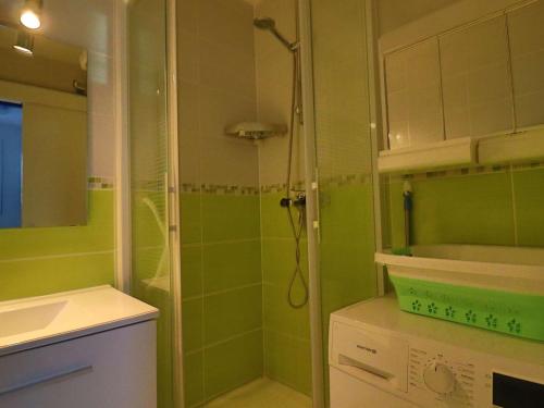 une salle de bain verte avec une douche et un lavabo dans l'établissement Charmant appartement avec jardin, proche plages, commerces et Royan, parking privé - FR-1-494-195, à Saint-Georges-de-Didonne
