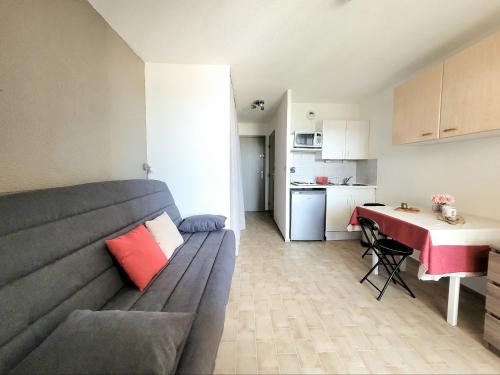 un salon avec un canapé et une table dans l'établissement Canet-en-Roussillon Studio cabine - 4 pers, vue mer, ascenseur, parking, animaux admis - FR-1-794-135, à Canet