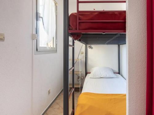 Cette chambre comprend des lits superposés et une valise rouge. dans l'établissement Canet-en-Roussillon Studio cabine - 4 pers, vue mer, ascenseur, parking, animaux admis - FR-1-794-135, à Canet