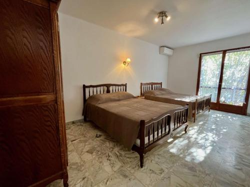 une chambre avec deux lits et une fenêtre dans l'établissement Maison 3 pièces avec jardin, à 2 pas du centre, 8 couchages, parking, clim et ménage inclus - FR-1-226B-208, à Cavalaire-sur-Mer