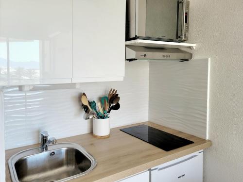 una cocina con fregadero y encimera en Canet-en-Roussillon T2 Moderne - Parking - Clim - 2ème étage avec ascenseur - 4 pers - FR-1-794-136, en Canet-en-Roussillon