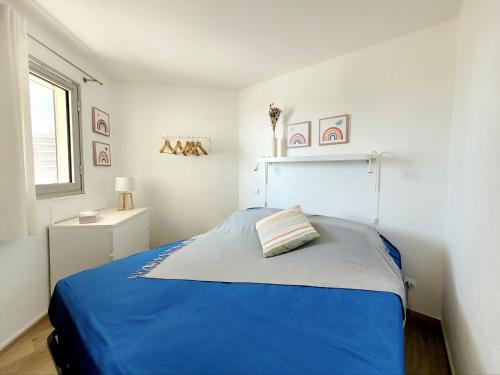 Un dormitorio con una cama azul y una ventana. en Canet-en-Roussillon T2 Moderne - Parking - Clim - 2ème étage avec ascenseur - 4 pers - FR-1-794-136, en Canet-en-Roussillon