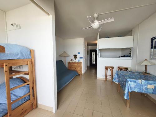 une chambre avec deux lits superposés et une table dans l'établissement Canet-en-Roussillon - Studio cabine 4/5 pers - bord de mer avec parking - FR-1-794-144, à Canet