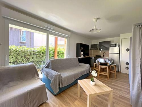 un salon avec un canapé et une table dans l'établissement Studio Rénové avec Jardin Privé et Parking - Proche Berck Ville et Plage - FR-1-646-66, à Berck-sur-Mer