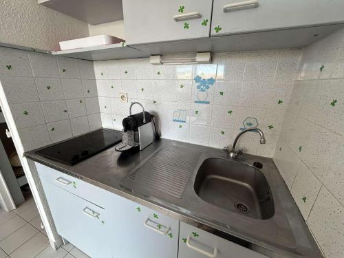 La cuisine est équipée d'un évier et d'un grille-pain. dans l'établissement Studio cabine confortable, terrasse, proche plage et commerces - Le Grau du Roi - FR-1-250-284, au Grau-du-Roi