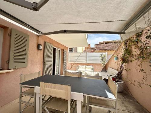 un patio avec une table et des chaises sur un balcon dans l'établissement Charmant T2 en Centre-Ville, Terrasse, Clim et Parking, Proche Plage et Commodités - FR-1-226-550, à Sainte-Maxime