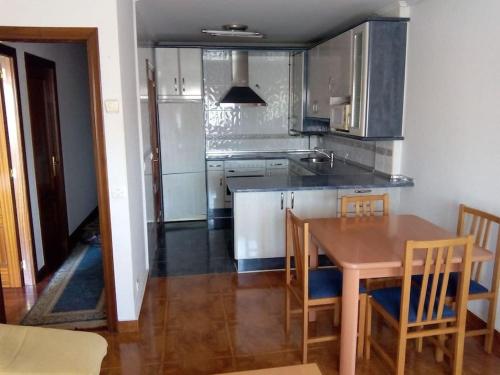 a kitchen with a wooden table and a table and chairs at Apartamento con piscina privada No mascotas in Medina de Pomar