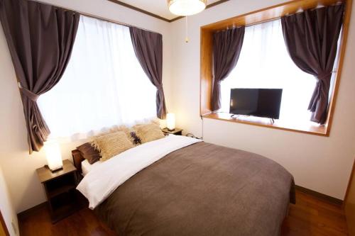 Postel nebo postele na pokoji v ubytování URASOE House