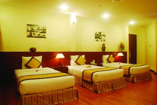a hotel room with two beds and two lamps at Hau Giang Hotel in Can Tho