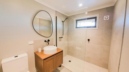 ein Badezimmer mit Dusche, Waschbecken und Spiegel in der Unterkunft The Staggerinn in Dinner Plain