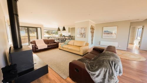 Ein Mann liegt auf einer Couch im Wohnzimmer. in der Unterkunft The Staggerinn in Dinner Plain