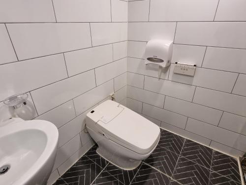 a white bathroom with a toilet and a sink at Jamsil Funny Hotel in Seoul