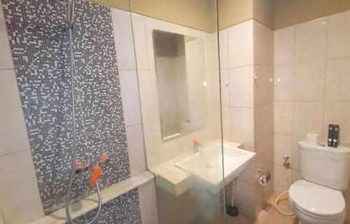 a bathroom with a shower and a toilet and a sink at Student Park Apartment by AS Room in Seturan