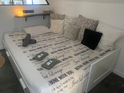 un lit avec un couvre-lit blanc avec des téléphones dessus dans l'établissement Très joli studio à Montpellier, à Montpellier