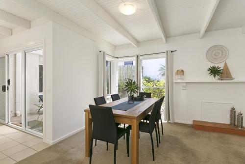 a dining room with a table and chairs at Mysa Anglesea Sleeps 7 WiFi SmartTV Cafes Shops in Anglesea