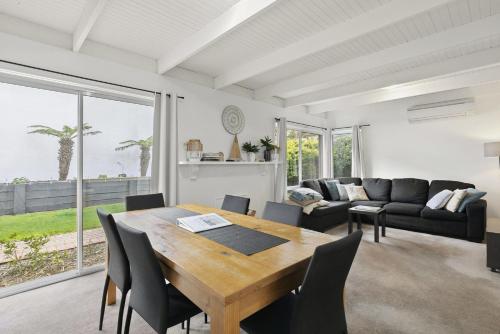 a living room with a wooden table and chairs at Mysa Anglesea Sleeps 7 WiFi SmartTV Cafes Shops in Anglesea