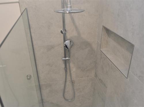 a shower with a glass door in a bathroom at Mysa Anglesea Sleeps 7 WiFi SmartTV Cafes Shops in Anglesea