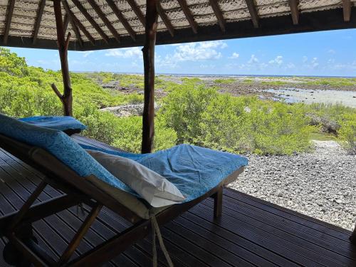 a bed on a porch with a view of the beach at Rangiroa Bliss in Tiputa