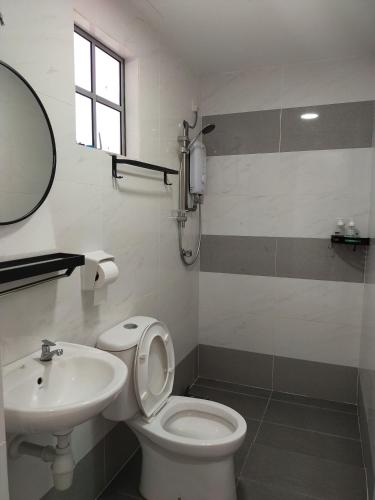 a bathroom with a white toilet and a sink at Seruni Apartment - 3 Bedrooms in Serendah