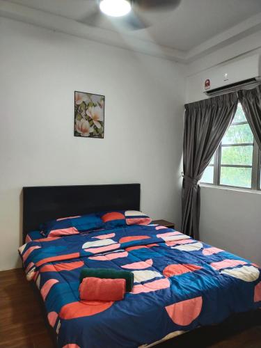 a bedroom with a large bed with a colorful comforter at Seruni Apartment - 3 Bedrooms in Serendah
