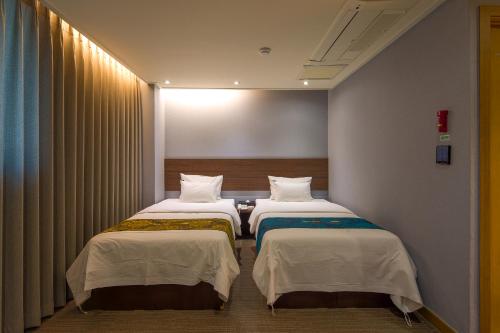 a room with two beds in a room at Namsan Hill Hotel in Seoul