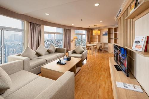 a living room with a couch and a tv at Super Hotel Candle in Hanoi