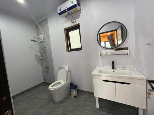 a bathroom with a toilet and a sink and a mirror at Hoàng Yến Garden Villa Bavi - Venuestay in Hanoi