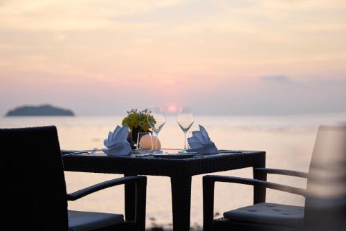 a table with wine glasses and napkins on the beach at The Chill Resort and Spa, Koh Chang in Ko Chang