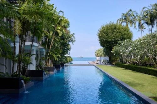 a swimming pool with palm trees next to a building at The Chill Resort and Spa, Koh Chang in Ko Chang