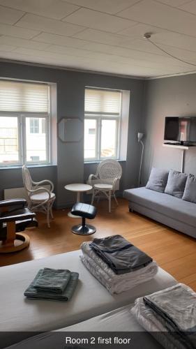 a living room with a bed and a couch and chairs at Byens Bed and Bath in Nakskov