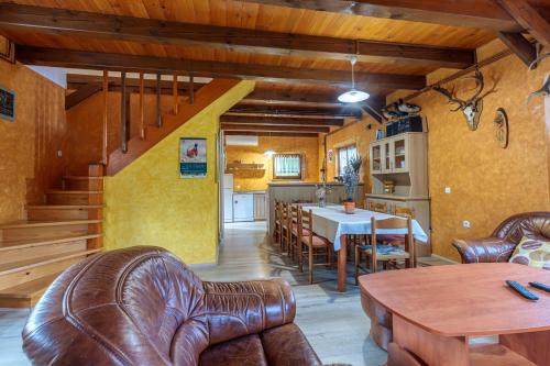 a living room with leather chairs and a table at Chalet Zavrh with Private Heated Pool - Happy Rentals in Brod Moravice