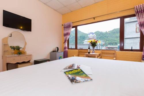 une chambre avec une table et un magazine. dans l'établissement olivia Hotel, à Sa Pa