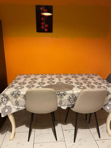 a table with two chairs and a table with a table cloth at Location Chambres chez Zam in Bandrélé