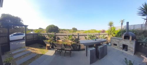 a patio with a grill and a table and chairs at Beachfront Surfers Retreat in Cape Woolamai