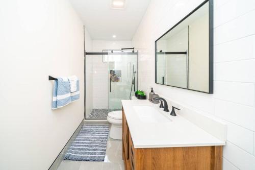 Un baño con lavabo, inodoro y espejo. en 80-2 4BR Boston - Bright Family Stay near PJP II Park, en Boston