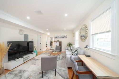 a living room with a couch and a television at 80-2 4BR Boston - Bright & Spacious Apt Family Stay near PJP II Park in Boston