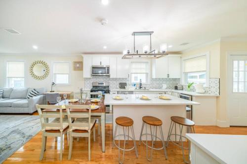 a kitchen with a table and some stools in it at 80-2 4BR Boston - Bright & Spacious Apt Family Stay near PJP II Park in Boston