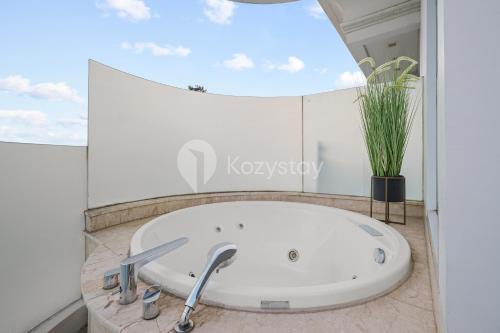 a large white bath tub in a room with a window at Bona by Kozystay - Ciumbuleuit in Bandung