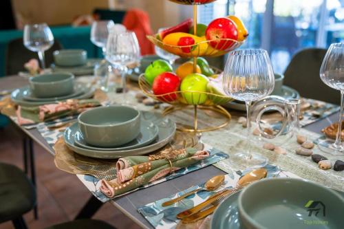 a table with plates and bowls of fruit and wine glasses at Cozy Heaven Treeview House for Dream Trip in Springfield Lakes