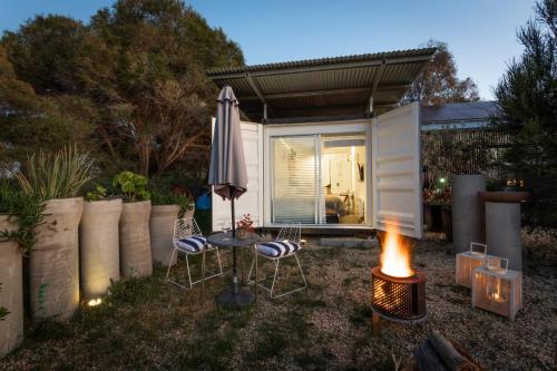 a small backyard with a table and chairs and an umbrella at Mia Mia House in Redesdale