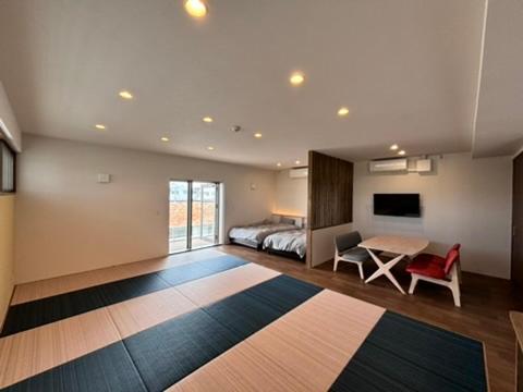 Un dormitorio con una cama, un escritorio y una mesa. en 島の宿 Amanzaーアマンツァー, en Ishigaki Island