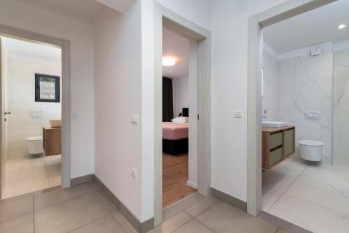 a bathroom with a toilet and a bed in a room at Maca Apartments & Suites in Trogir