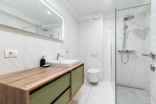 a bathroom with a sink and a toilet and a shower at Maca Apartments & Suites in Trogir